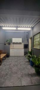 a kitchen with white cabinets and plants in a room at Pousada Palmeira in Viracopos