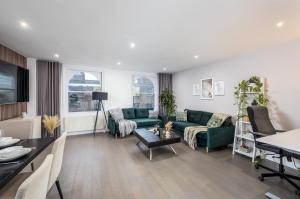 a living room with a green couch and a table at Luxury 2 Bedroom Apartment next to Angel in London