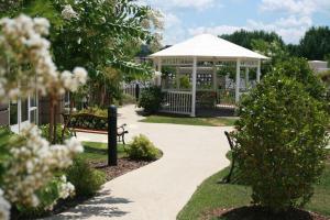 einen Garten mit einem Pavillon und einer Bank in der Unterkunft Hampton Inn Guntersville in Guntersville