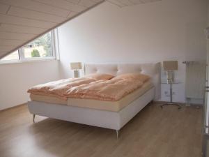 um quarto com uma cama num quarto branco em Holiday apartment Taunustraum in Hohenstein Hesse 