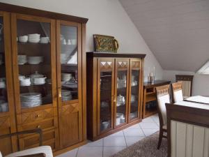 uma cozinha com armários de madeira com pratos e pratos em Holiday apartment Taunustraum in Hohenstein Hesse 