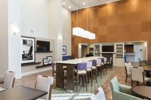 uma grande sala de jantar com uma mesa longa e cadeiras em Hampton Inn & Suites Hartford-Manchester em Manchester