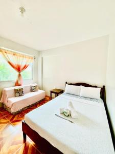 a bedroom with two beds and a window at FIESTA HAUS RESORT in Boracay