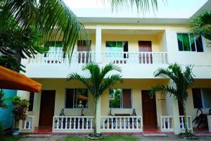 a building with palm trees in front of it at FIESTA HAUS RESORT in Boracay