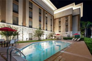 uma piscina em frente a um hotel à noite em Hampton Inn Houston/Humble-Airport Area em Humble