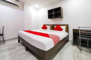 a bedroom with a large bed with red pillows at Hotel Seven S in New Delhi