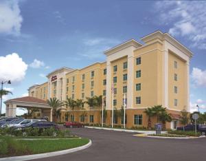 a large yellow hotel with cars parked in a parking lot at Hampton Inn & Suites Homestead Miami South in Homestead