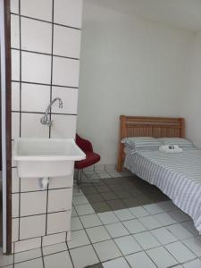 baño con lavabo y cama en Excelentes Quartos com banheiros privativos, en Recife