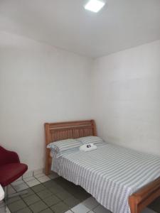 レシフェにあるExcelentes Quartos com banheiros privativosの小さなベッドルーム(ベッド1台、赤い椅子付)