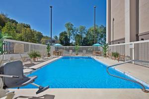 a swimming pool at a hotel with a chair at Hampton Inn Huntington/Barboursville in Barboursville
