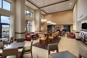 a restaurant with tables and chairs and a bar at Hampton Inn & Suites Charles Town in Charles Town