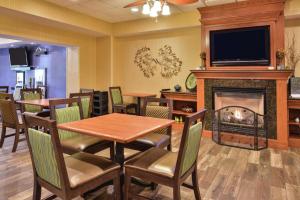 a restaurant with tables and chairs and a fireplace at Hampton Inn Harrisonburg South in Harrisonburg