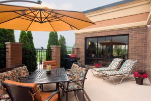 a patio with a table and chairs and an umbrella at Hampton Inn & Suites Crawfordsville in Crawfordsville