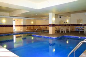 una gran piscina en un hotel con mesas y sillas en Hampton Inn & Suites Kingman en Kingman