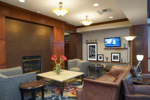 a lobby with a fireplace and chairs and a table at Hampton Inn and Suites Indianapolis-Fishers in Fishers