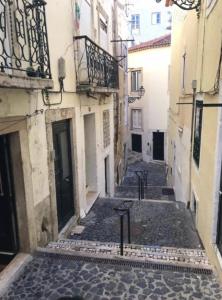 an alley in an old town with cobblestone at Cosy Mouraria Rooms in Lisbon