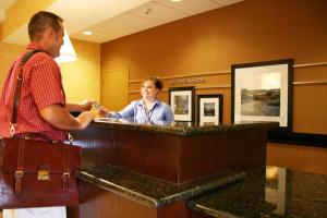 un hombre parado en un mostrador en una habitación de hotel en Hampton Inn & Suites Dobson, en Dobson