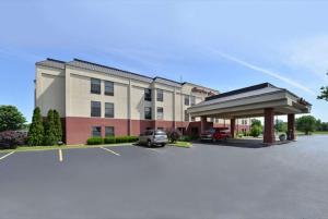 a building with a car parked in a parking lot at Hampton Inn Sturgis in Sturgis