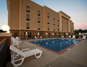 a hotel with a pool and chairs and a building at Hampton Inn Yazoo City in Yazoo City