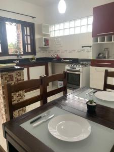 a kitchen with a table with a white plate on it at Apto bem equipado, com 2 quartos acomoda até 6 pessoas confortavelmente in Ubatuba
