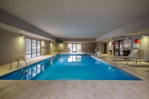 una gran piscina con agua azul en una habitación de hotel en Hampton Inn Janesville en Janesville