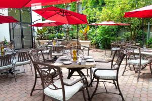 mesas y sillas con sombrillas rojas en un restaurante en Hampton Inn & Suites Fairfield en Fairfield