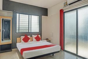 Hotel Green Leaves في Māngvādi: غرفة نوم بسرير ونافذة كبيرة