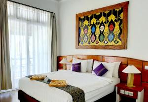 ein Schlafzimmer mit 2 Betten und einem Wandgemälde in der Unterkunft The Trawangan Resort in Gili Trawangan