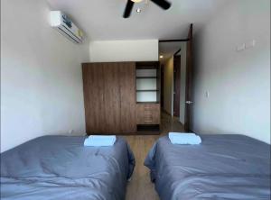 um quarto com 2 camas e um armário de madeira em D2 Departamento Centrico Mérida em Mérida