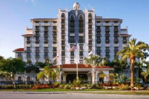 un grand bâtiment avec des palmiers devant lui dans l'établissement Embassy Suites by Hilton Fort Lauderdale 17th Street, à Fort Lauderdale
