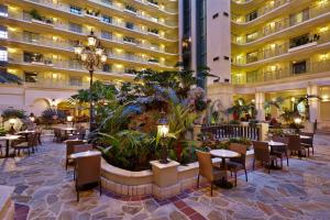 a hotel lobby with tables and chairs and a large building at Embassy Suites by Hilton Fort Lauderdale 17th Street in Fort Lauderdale