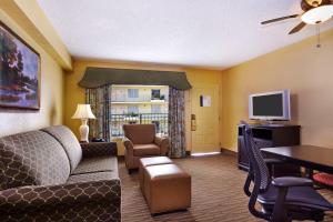 a living room with a couch and a tv at Embassy Suites by Hilton Fort Lauderdale 17th Street in Fort Lauderdale