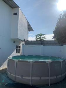 uma piscina em frente a uma parede branca em Casa San Jacinto em Rocafuerte