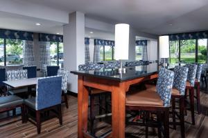 een eetkamer met een bar met stoelen en ramen bij Hampton Inn Fall River/Westport in North Westport