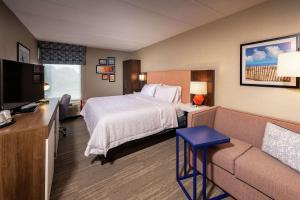 a hotel room with a bed and a couch at Hampton Inn Fall River/Westport in North Westport