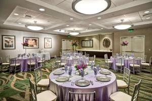 a banquet room with tables and chairs with purple tablecloths at Embassy Suites Fort Myers - Estero in Estero