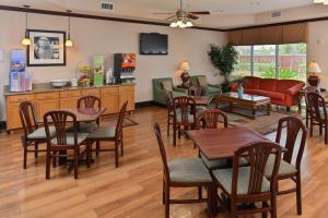 een woonkamer met tafels en stoelen en een bank bij Hampton Inn Houston-Deer Park Ship Area in Deer Park