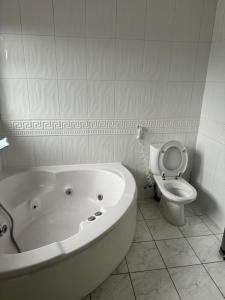 La salle de bains est pourvue d'une baignoire et de toilettes. dans l'établissement Krystal Residence, à Londres