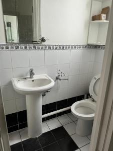 a bathroom with a sink and a toilet at Krystal Residence in London