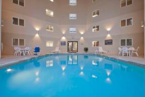 - une piscine dans un bâtiment avec des chaises et des tables dans l'établissement Hampton Inn Indianapolis Northeast/Castleton, à Indianapolis