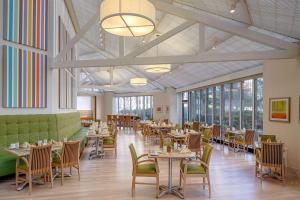 a dining room with tables and chairs and windows at DoubleTree by Hilton Hotel Houston Greenway Plaza in Houston