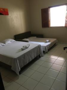 two beds sitting next to each other in a room at Casa De Benedictis Rio de Contas in Rio de Contas