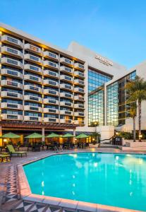 ein Hotel mit einem Pool vor einem Gebäude in der Unterkunft DoubleTree by Hilton San Jose in San Jose