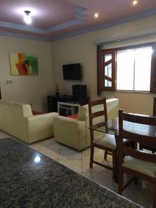 a living room with couches and a table and a television at Casa De Benedictis Rio de Contas in Rio de Contas