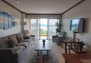 uma sala de estar com um sofá e uma televisão em Sunset Heights 402 em Playa Flamingo