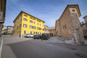 a yellow building with cars parked in front of it at Residence Belvedere ristrutturato vista Wifi in Caprino Veronese