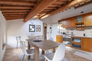 a kitchen and dining room with a wooden table and chairs at Residence Belvedere ristrutturato vista Wifi in Caprino Veronese