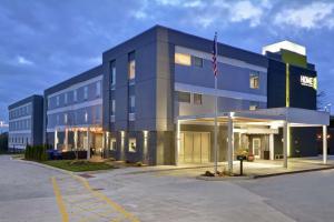 Um edifício azul com uma bandeira americana à frente. em Home2 Suites By Hilton Grand Rapids North em Grand Rapids