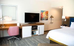 a hotel room with a bed and a desk with a television at Hampton Inn Lebanon in Lebanon