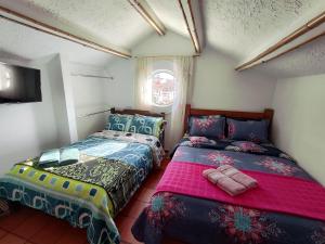 a bedroom with two beds and a window at Casa de Chavela in Villa de Leyva